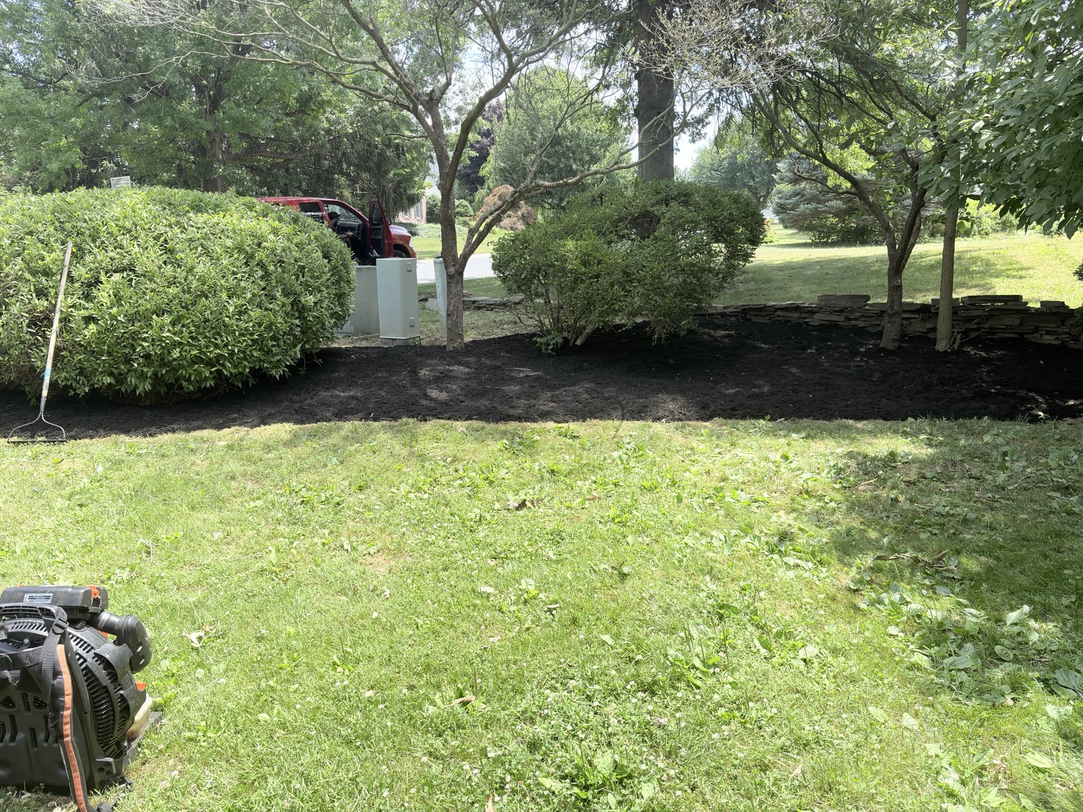 Landscape bed cleanup with shrubs and fresh mulch in Lancaster PA