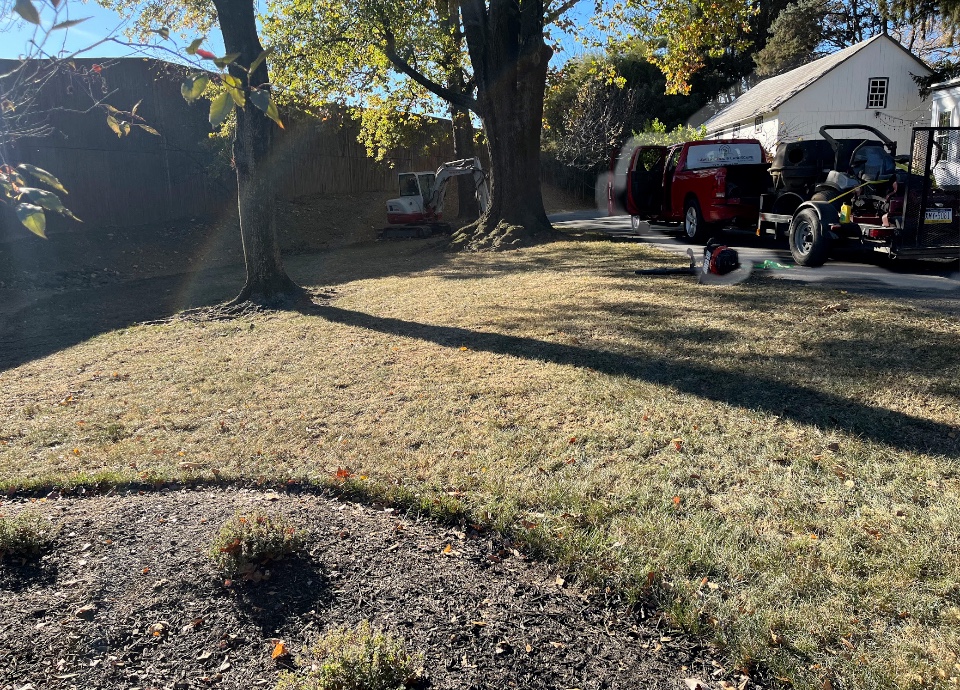 Large lawn cleared of leaves with Lawn Patrol truck and equipment on site
